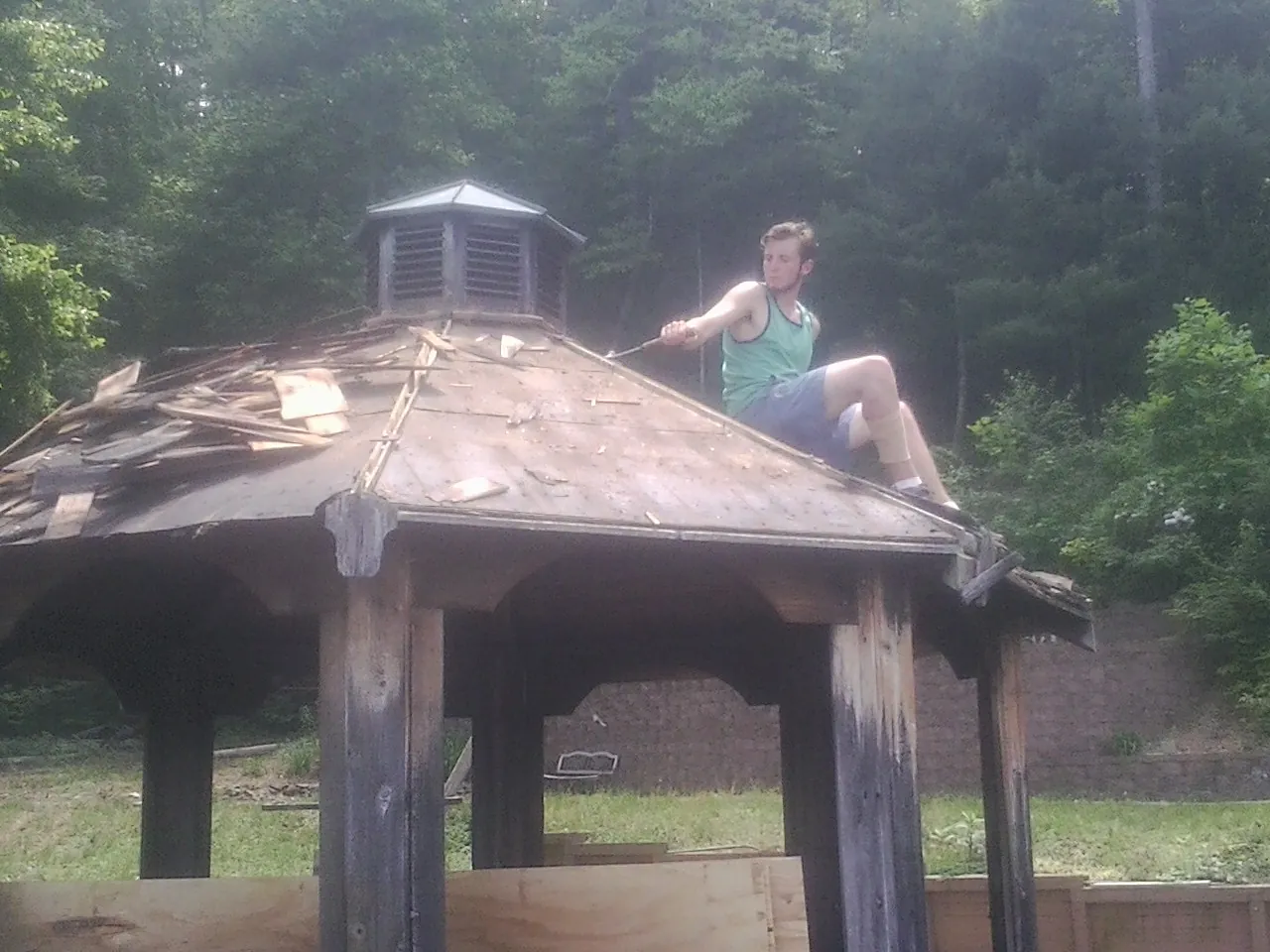 Tearing the old roof off a wooden gazebo before new shakes in Jefferson Valley