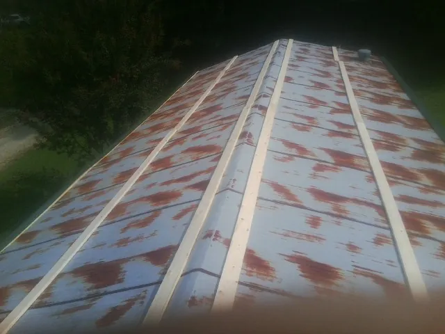 Rusted metal roof panels with new wood purlins before replacement — Storm Damage Roof Repair in Jefferson Valley by Roofing Brothers