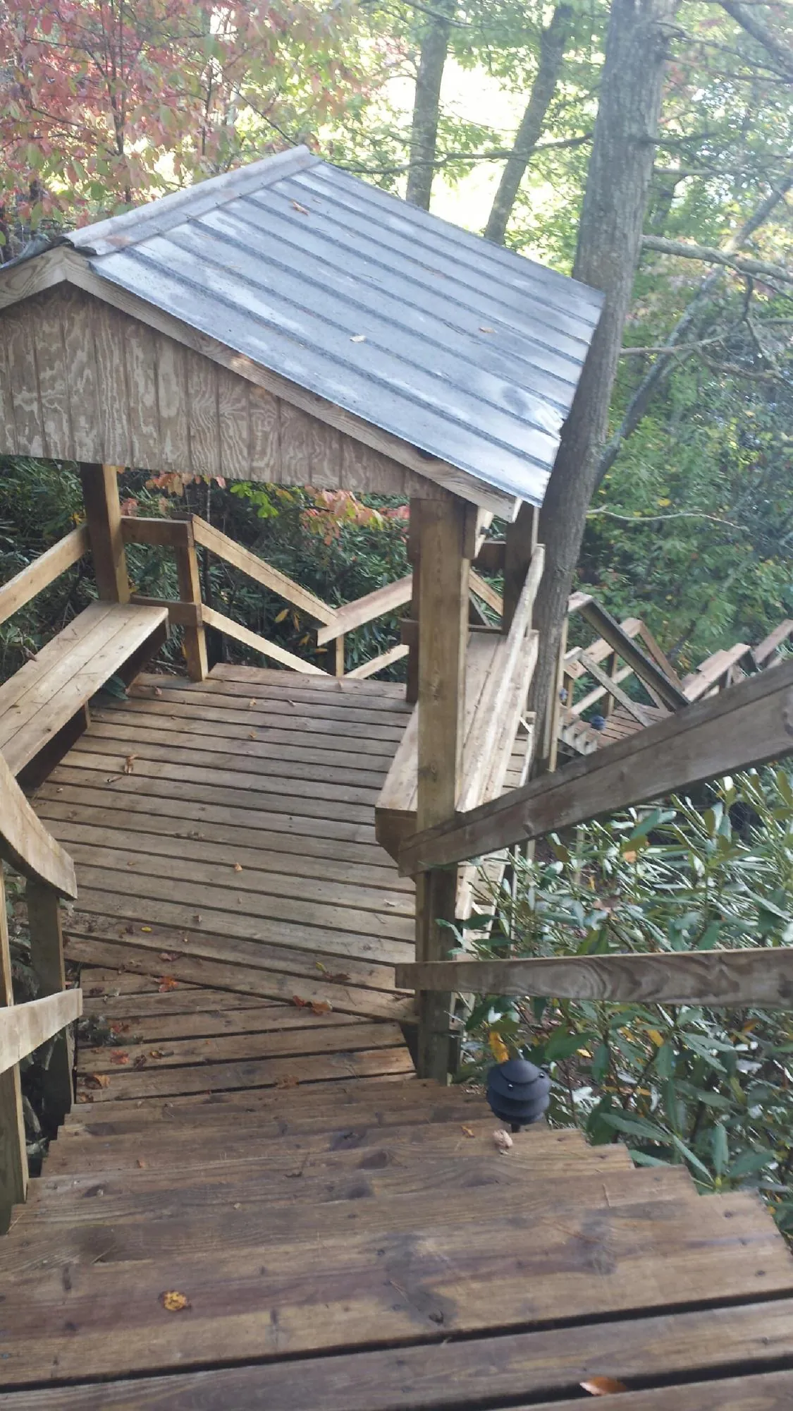 Metal roofed shelter over wooden steps on a wooded walkway — Skylight Repair & Installation work by our crew in Jefferson Valley