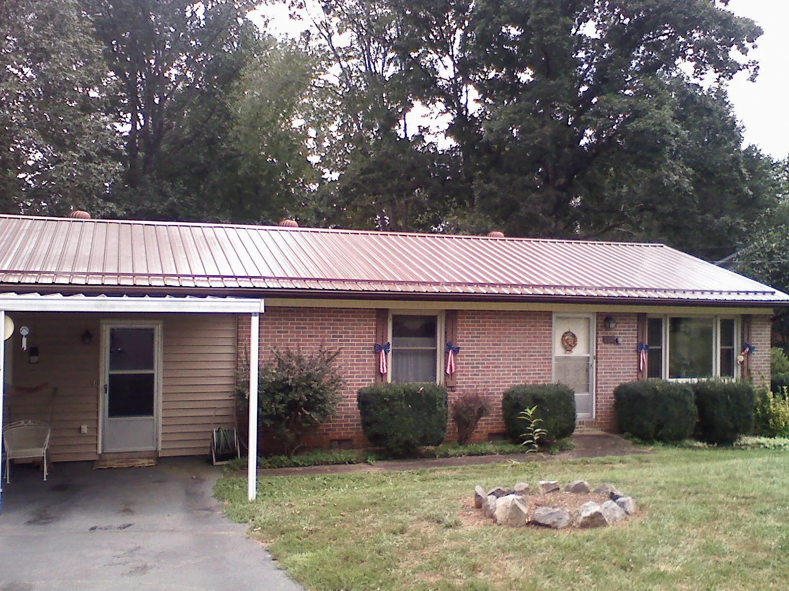 Bronze metal roof and carport on a brick ranch home — Roof Repair work by our crew in Jefferson Valley